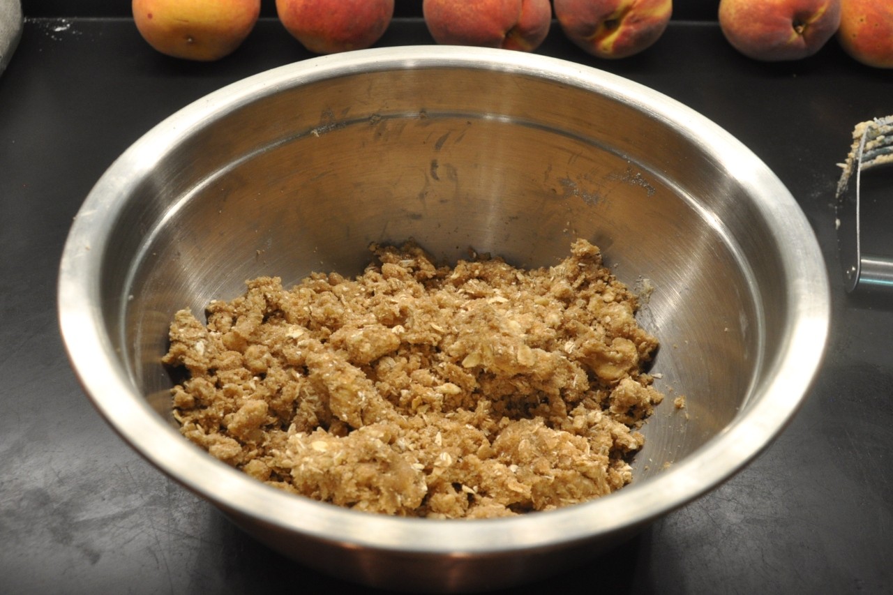 Prepare the sweet and nutty crumble crust and topping for Peach Crumble Pie.