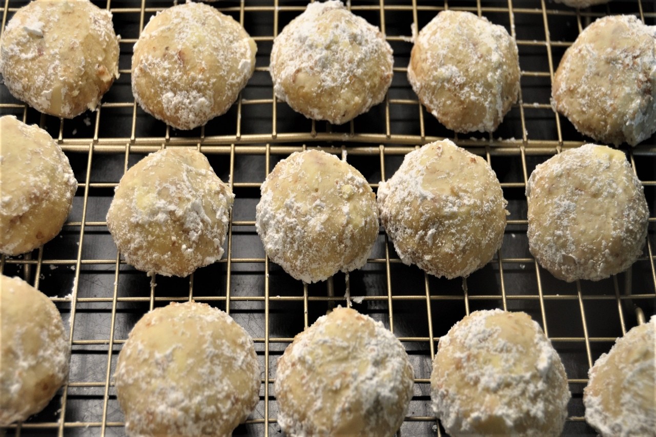 Orange shortbread cookie rolled in powdered sugar and stuffed with pecans and mini chocolate chips.