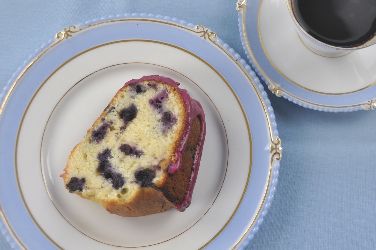 A slice of heavenly Lemon Blueberry Pound Cake packed with blueberries and flavored with lemon. Topped with thick, rich blueberry glaze.